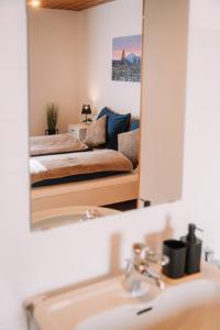 a mirror over a sink with a couch in a living room at Alpenblick Gösweiner in Windischgarsten +51 photos