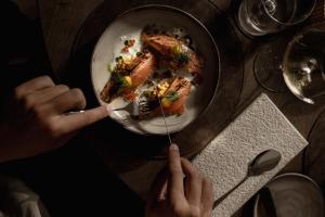 a person eating a plate of food with a fork at stieg'nhaus Design Boutique Hotel in Mühlbach am Hochkönig