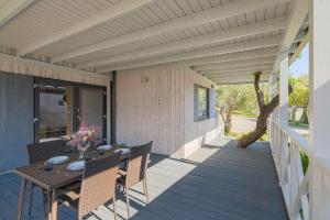 a patio with a table and chairs on a deck at Elements Camping Selce Mobile homes in Selce