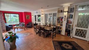 a living room with a table and chairs and red walls at TheBlueDoor in Greyton