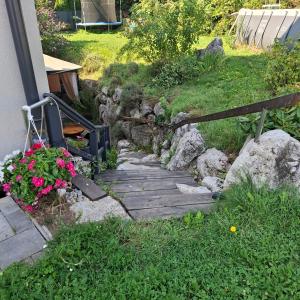 a wooden pathway with flowers on the side of a house at Relax-Apartment mit Sauna in Klagenfurt