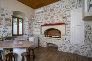 a kitchen with a stone wall with a fireplace at Galini & Serena Apartments in Symi +51 photos