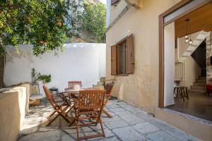a patio with a wooden table and chairs at Galini & Serena Apartments in Symi
