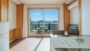a kitchen with a table and a large window at Yeongheungdo Rainbow Ocean View Pension in Incheon +11 photos