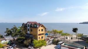 an aerial view of a yellow house with the ocean at Yeongheungdo Rainbow Ocean View Pension in Incheon