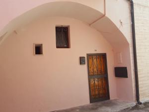 een boog met een deur en een luidspreker aan een muur bij Dimora di Mara in Santeramo in Colle