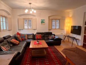 a living room with a leather couch and a coffee table at Alpine Retreat - Lake Bled in Bled