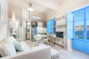 a living room with a white couch and blue cabinets at ARTEMIS SUITE in Agia Marina