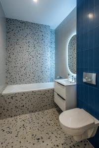 a bathroom with a toilet and a sink and a tub at Velora Apartments in Năvodari +68 photos