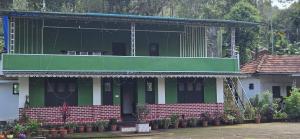 a green and white building with a balcony at Coffee land in Kaniyāmbetta