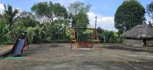 two swings in a parking lot next to a hut at Coffee land in Kaniyāmbetta