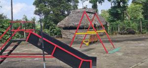 a playground with a slide in front of a hut at Coffee land in Kaniyāmbetta