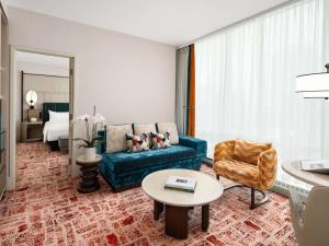 ein Wohnzimmer mit einem blauen Sofa und einem Tisch in der Unterkunft Sofitel Montreal Golden Mile in Montreal + 124 Fotos