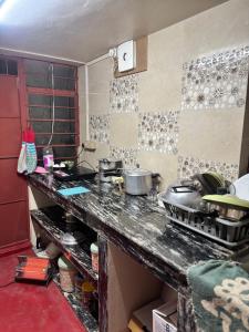 a kitchen with a counter top with pots and pans at Shillong Backpackers Hostel in Shillong