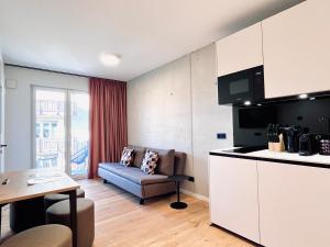 a kitchen and living room with a couch and a table at Mikes Apartments Munich in Munich