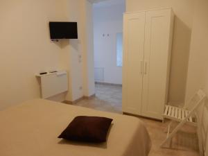 a bedroom with a bed and a cabinet and a television at C'era Una Volta in Bastia Umbra