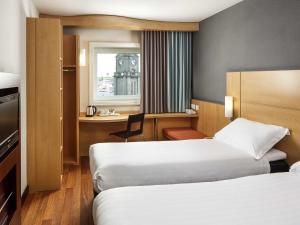 a hotel room with two beds and a desk at ibis Aberdeen Centre – Quayside in Aberdeen +76 photos