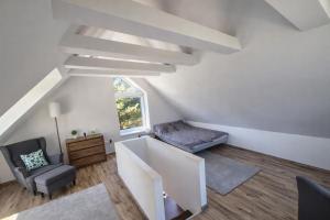 an attic room with a staircase and a chair at Badacsonyi rege in Badacsonytördemic