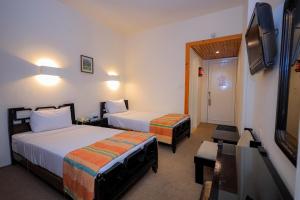 a hotel room with two beds and a flat screen tv at Cleopatra Hotel in Aswan