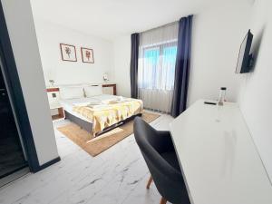 a bedroom with a bed and a desk with a chair at RUBO Hotel in Shumen