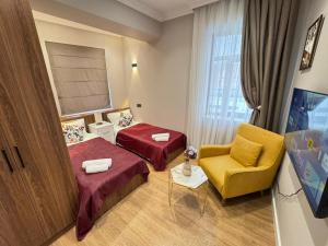 a hotel room with two beds and a chair at Maiden Tower Prestige in Baku