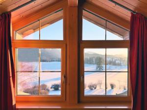 a window in a room with a view of a snowy field at Sonnenhof Seeg 19 in Seeg