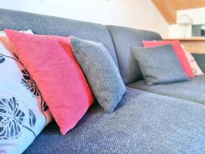 a couch with three pillows sitting on it at Sonnenhof Seeg 19 in Seeg