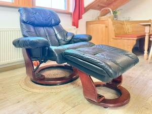 a blue leather reclining rocking chair with a stool at Sonnenhof Seeg 19 in Seeg