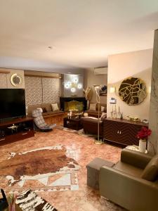 a living room with a couch and a television at luxury house airport in Koropi