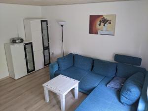 a living room with a blue couch and a table at Ferienwohnung am Park in Greiz