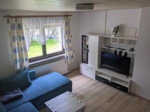 a living room with a blue couch and a tv at Ferienwohnung am Park in Greiz