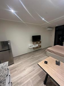 a room with a bed and a table and a tv at Solis Residence Batumi in Batumi