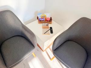 two chairs sitting next to a table with a remote control at RUBO Hotel in Shumen