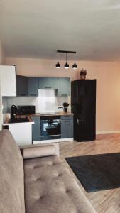 a kitchen with a couch and a black refrigerator at Apartament OLIWIA 5 in Nowy Targ