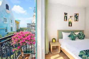 a bedroom with a bed and a balcony with pink flowers at Casa Del Mar Hotel & Apartment - Sunset Town, Phu Quoc in Phú Quốc +94 photos