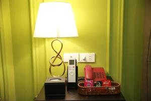 a lamp sitting on a table next to a telephone at Gấu Hotel Cầu Giấy in Hanoi
