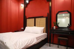 a bedroom with a bed and a mirror and a dresser at Gấu Hotel Cầu Giấy in Hanoi