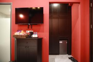 a room with red walls and a flat screen tv at Gấu Hotel Cầu Giấy in Hanoi