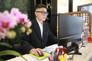 a man in glasses sitting at a desk with a computer at Gấu Hotel Cầu Giấy in Hanoi +10 photos