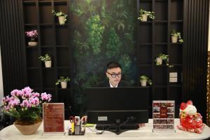 a man sitting at a desk in front of a computer at Gấu Hotel Cầu Giấy in Hanoi