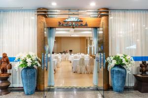 a banquet hall with white tables and blue vases with flowers at Summit Pavilion Hotel in Bangkok
