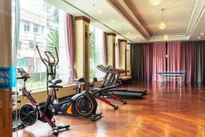 a gym with treadmills and exercise bikes in a room at Summit Pavilion Hotel in Bangkok