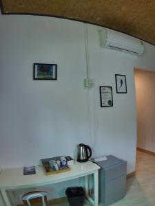 a room with a table and a white wall at Little Shark bungalow in Ban Bang Bao