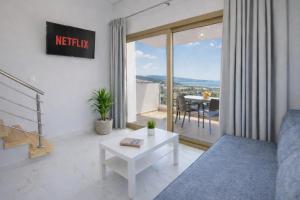 a living room with a couch and a table at MPL Apartments & maisonettes in Limenaria