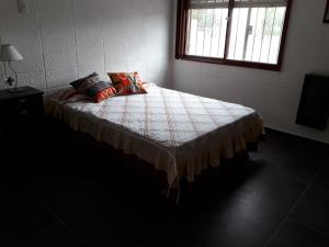 1 dormitorio con 1 cama con 2 almohadas en La Chicharra en Villa Carlos Paz
