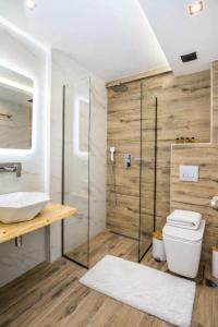 a bathroom with a glass shower and a toilet at MPL Apartments & maisonettes in Limenaria +35 photos