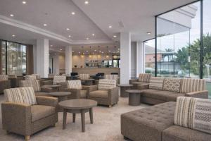 a lobby with couches and tables and a bar at Cala Millor Garden Hotel - Adults Only in Cala Millor