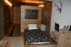 a small bedroom with a bed and a tv at Living Kampill in Bolzano