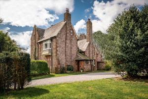 an old stone house with two chimneys on top at The Old Vicarage Irton in Parton
