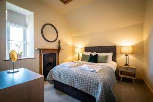 a bedroom with a bed with a mirror and a fireplace at The Old Vicarage Irton in Parton